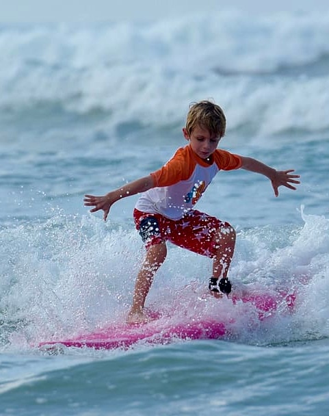 kid on a surfboard in costa rica near los suenos