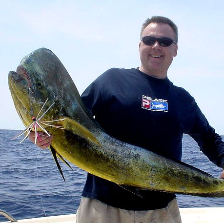 man with a dorado on a fishing trip